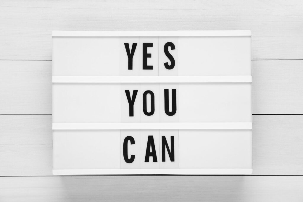 how to overcome the fear of starting your own business - change your mindset. a board with "yes, you can" written on it.