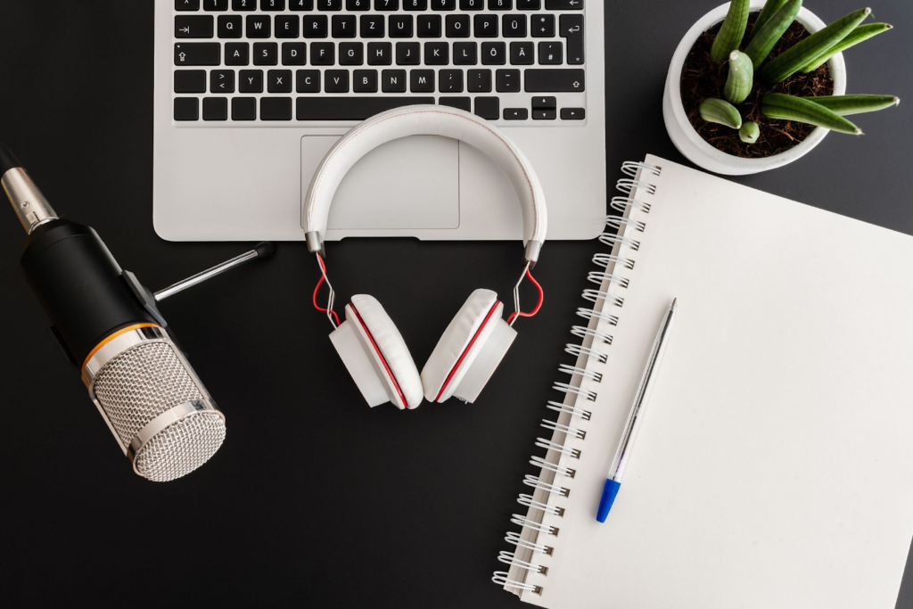 why personal branding is important and how to build one - through creating consistent content. a desk with paper, mic, headphones, and laptop on it