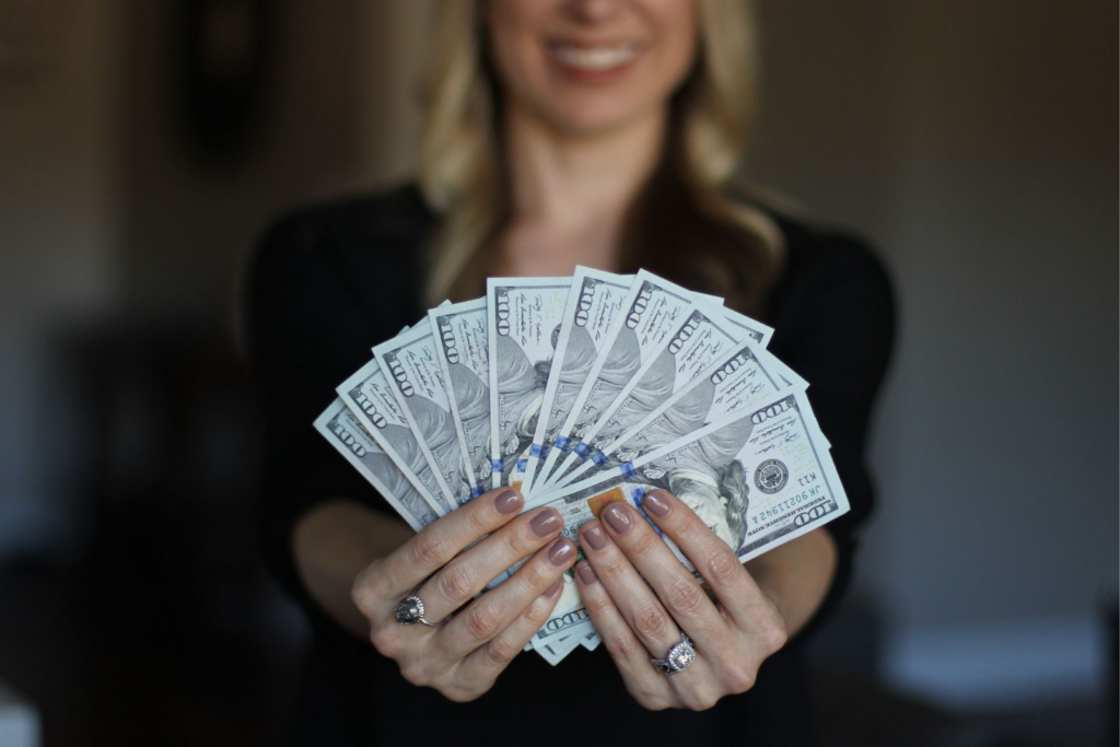 establish a positive money mindset - a woman holding some dollar bills