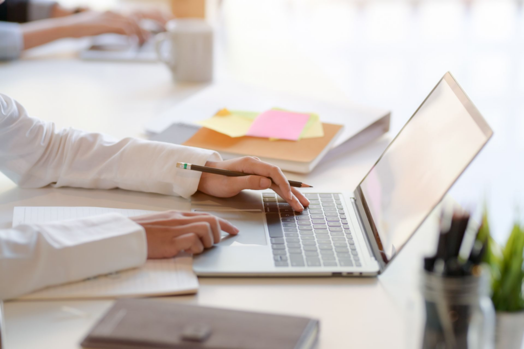 ways to invest in yourself - a laptop with some notebooks on the side to indicate aquiring skills